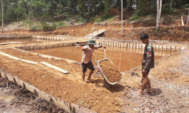 Anggota Satgas TMMD dan Warga Perkeras Bantaran Kolam Ikan