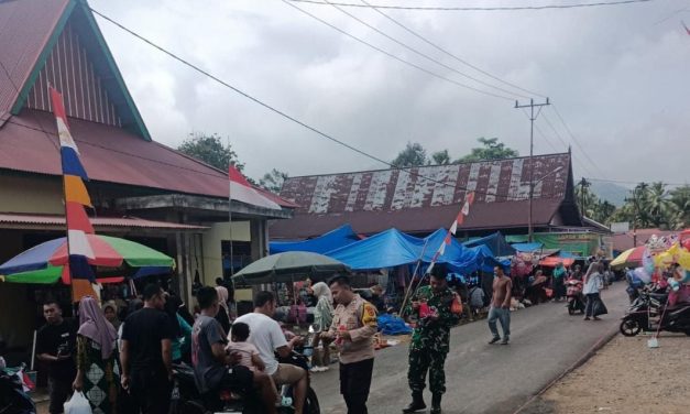 Babinsa dan Bhabinkamtibmas Bagikan Bendera Merah Putih di Desa Pasar Muara Siau